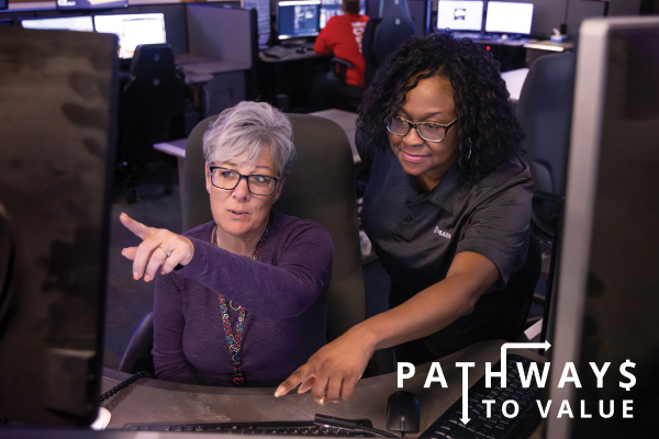 2 ladies pointing at screen feature
