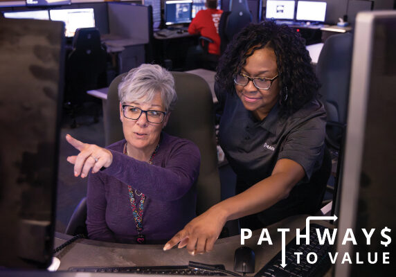 2 ladies pointing at screen feature